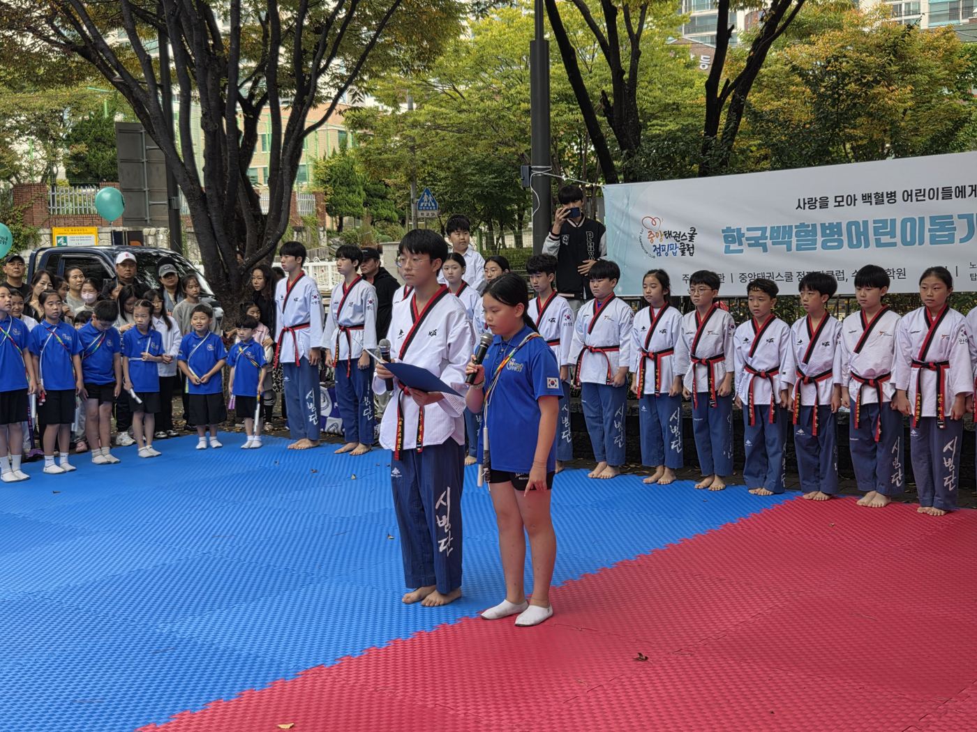 자선행사에서 인사말을 하는 시범단 학생들