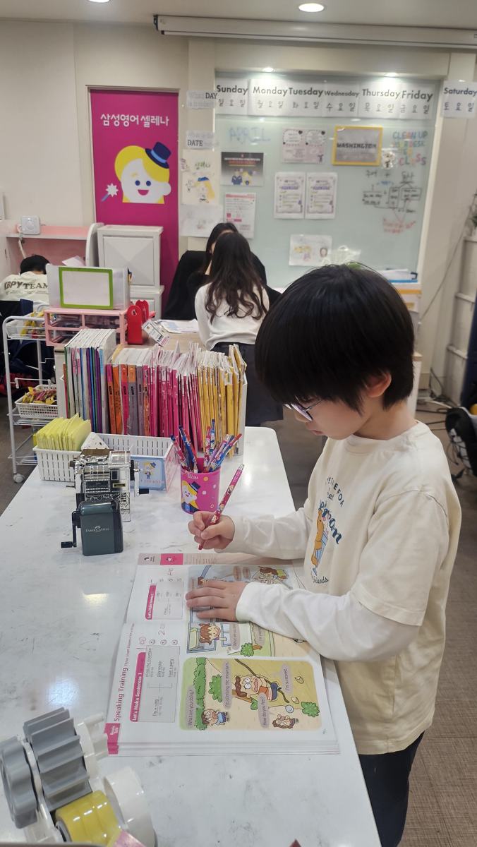 초등 영어 말하기 훈련 교재를 푸는 학생
